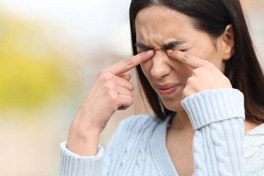 woman rubbing eyes from discomfort