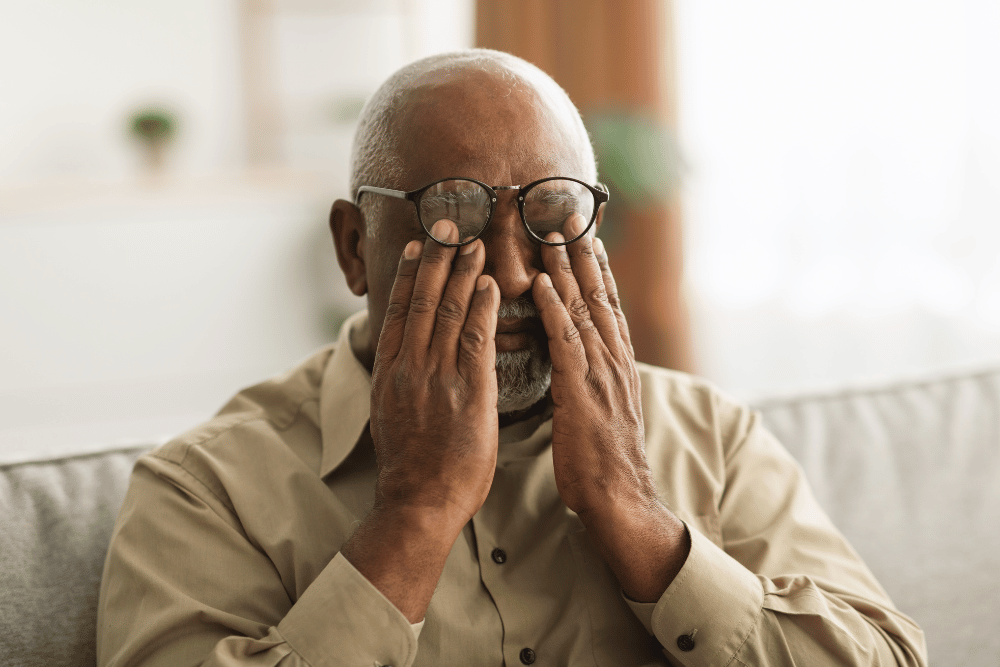 older man rubbing his eyes from discomfort